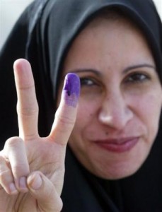 An Iraqi woman flashes victory after voting.